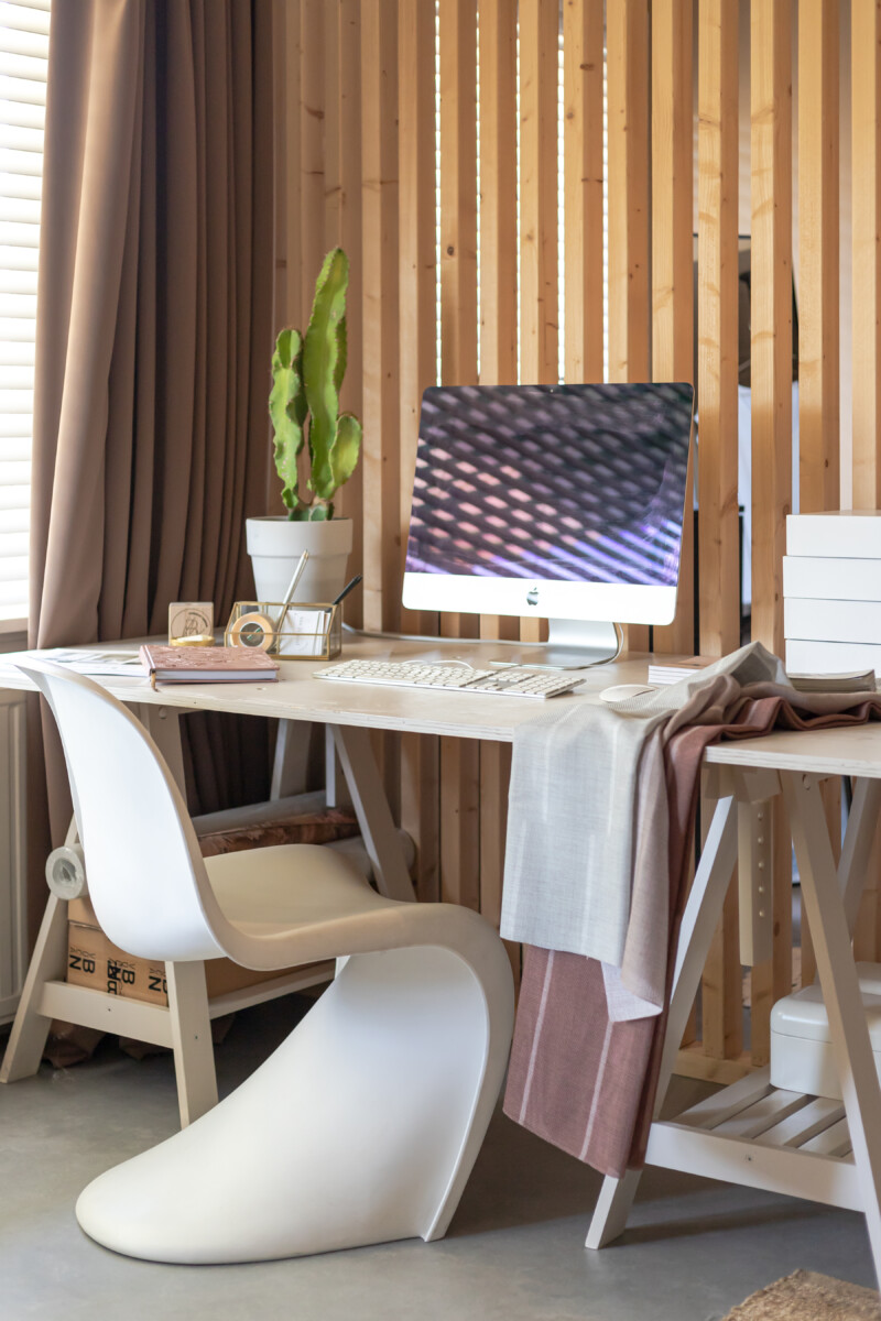 Sfeervolle thuiswerkplek in de woonkamer met een houten bureau en zachte kleuren